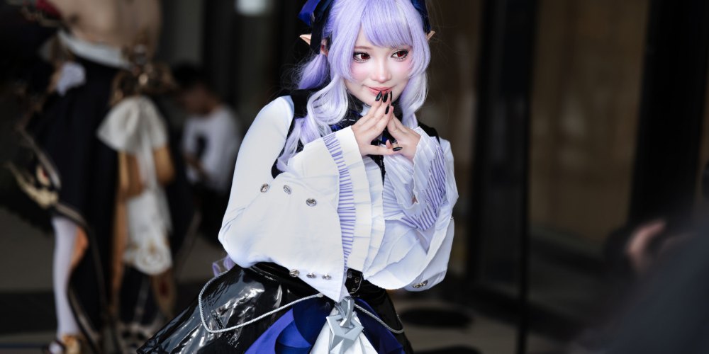紫の髪のキャラクターに扮したコスプレイヤー