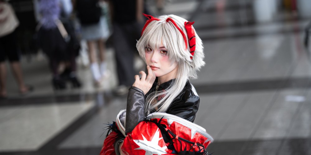 白い髪に赤い角のキャラクターに扮したコスプレイヤー